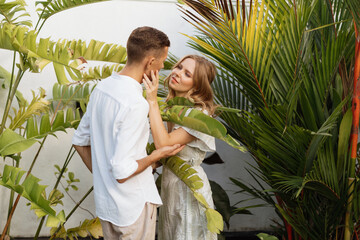 Happy european couple hugging in a tropical garden outdoors. Valentine's Day.