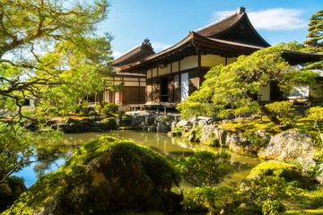 Fototapeta na wymiar Beautiful traditional Japanese architecture in the golden light with reflections in the pond at the Silver Pavillion or Ginkaku-Ji Zen Temple and gardens, a 'must-see' destination in Kyoto, Japan.