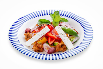 Greek salad with feta cheese and aromatic herbs. On a white background, isolated. Vegetarian dish.