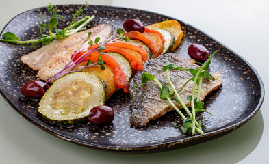 Sea bass fillet with vegetables ratatouille . On white background, isolated.