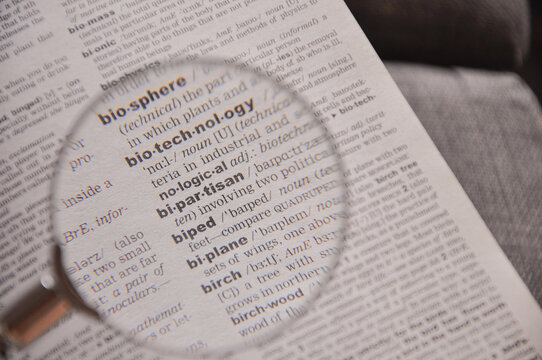 The definition of the word Bipartisan in a dictionary, under magnifying glass, translator and language concept