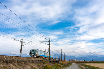 北アルプスをバックに走るあいの風とやま鉄道
