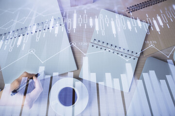 Multi exposure of woman's hands making notes with forex graph hologram. Concept of technical analysis.