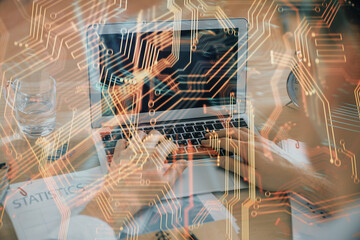 Technology theme hologram with man working on computer on background. High tech concept. Double exposure.