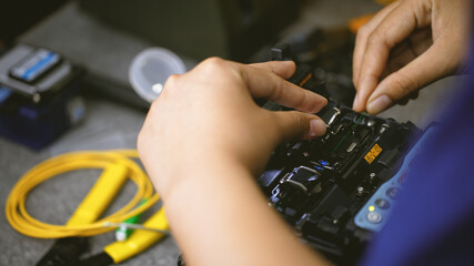 Fiberoptic Fusion Splicing Technician , Internet cable connection, fiber optic fusion splicing machine. Concept of fiber optic connection by skilled technicians.