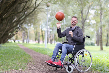 Happy smiling disabled man twirling basketball ball