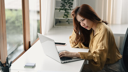 Stressed or tired businesswoman with laptop computer working at home office