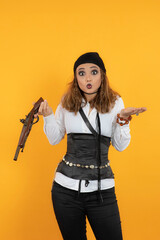 Shocked young pirate girl holding a gun and looking at the camera