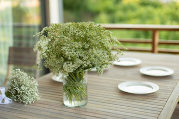 Vase on table. Dining table on veranda. Lunch in summer.