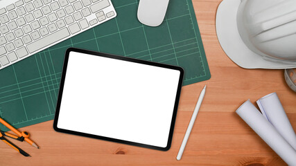 Architectural and Engineer office desk with digital tablet, helmet and blueprints. Top view, flat lay