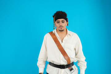 Portrait of a young handsome pirate stand on blue background.