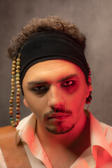 Close-up portrait of young pirate under red light