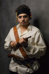 Young pirate holding gun and looking at camera