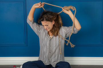 Young girl trying to suicide. Stressed girl putting rope around her neck