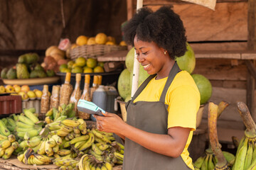 african market woman using a pos device and a credit card