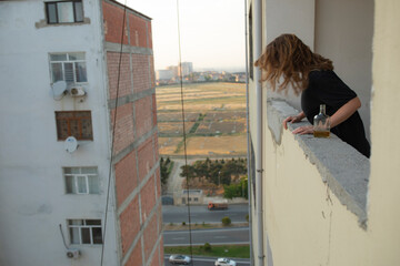 Drunk girl at the balcony looking at down and want to suicide.
