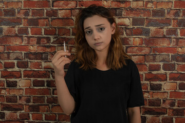 Fototapeta na wymiar Portrait of young depressed girl holding cigarette.