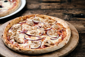 Pizza with tuna and red onion on wooden cutting board. - 516005679