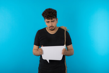 Upset young man holding idea board and put rope to his neck