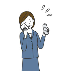 汗を拭きながら水分補給をするビジネスウーマン
