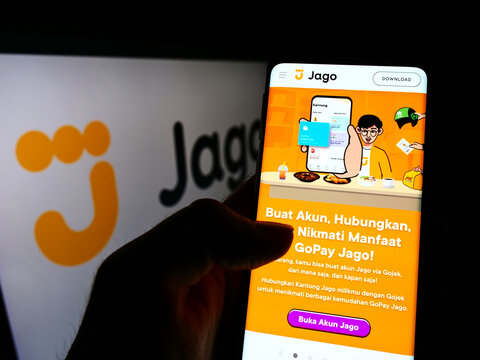 Stuttgart, Germany - 01-16-2022: Person holding cellphone with website of Indonesian financial company PT Bank Jago Tbk on screen with logo. Focus on center of phone display.