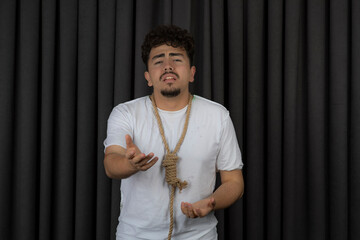 Portrait of depressed guy hanging rope around his neck and point hand at camera