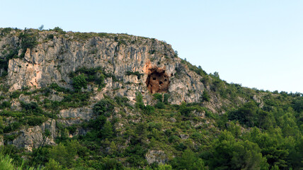 Fototapeta na wymiar Unusual caves in the rock above. Four caves. Mountains of Spain, Alicante