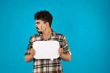 Creative young guy holding white idea board and looking at the right side
