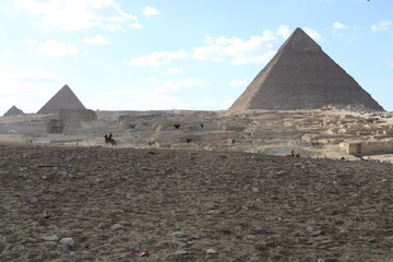 Fototapeta na wymiar Pyramids of Giza. Scene with tourists near pyramid in Egyptian desert. Travel to the African continent for look of a UNESCO World Heritage Site. 