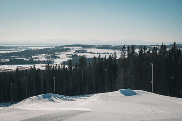 Alpine skiing slope (Ladängen, Frösön, Östersund) with a mountain view towards Storsjöbygden and Oviksfjällen at the border between swedish winter and spring.