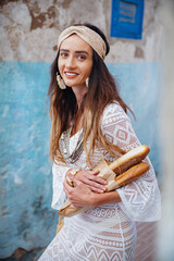 Portrait of a beautiful girl in a white dress with baguettes. Essaouira. Morocco.