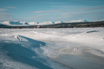 Melting ice (global warming concept) on lake Storsjö (Ljungdalen) with a mountain view of Helags...