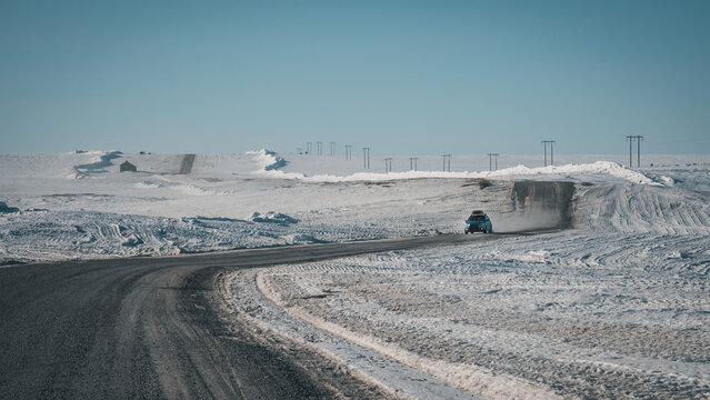 Road trip on Flatruet - Sweden's highest country road to mountain. Winter times on gravel road. Clouds of dust while car passes by rapidly.