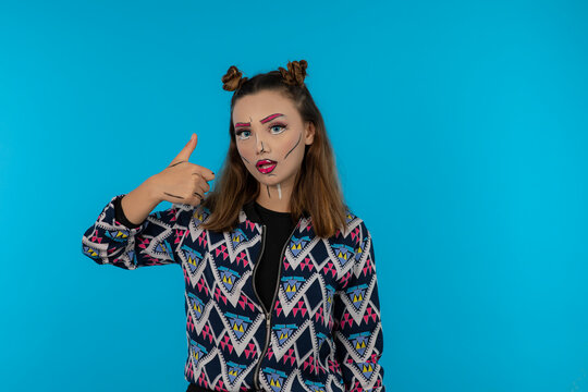 Portrait of attractive girl with creative makeup and gesturing thumb up