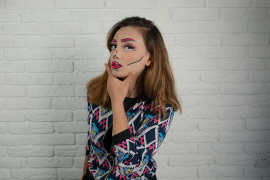 Portrait of young girl wearing creative makeup and put hand yo her chin