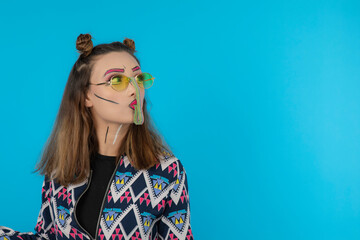 Attractive beautiful girl wearing fantasy makeup and eating marmalade