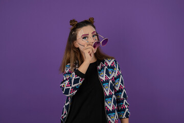 Portrait of youn girl with fantasy makeup taking off her glasses