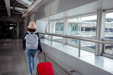 Fototapeta na wymiar Traveler with suitcase in airport concept.Young girl walking with carrying luggage and passenger for tour travel booking ticket flight at international vacation time in holiday rest and relaxation.