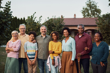 Happy multi-ethnic extended family in backyard looking at camera.