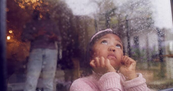 Sad girl avoiding her angry, shouting mother, looking out the window. Adorable little girl with from ADHD or autism, dreaming, watching rain condensation on steamy glass, struggling to concentrate