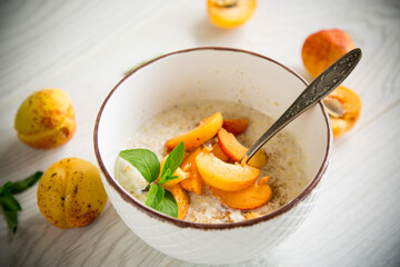 Healthy breakfast of apricot oatmeal with fresh fruit