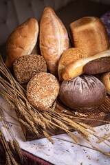 Freshly baked crusty bread and buns with wheat ears top view