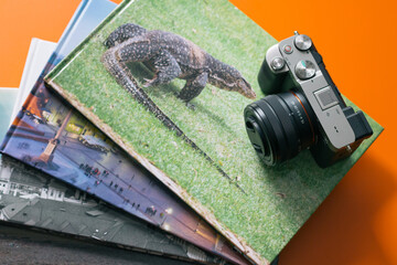 Camera with photo albums on orange table