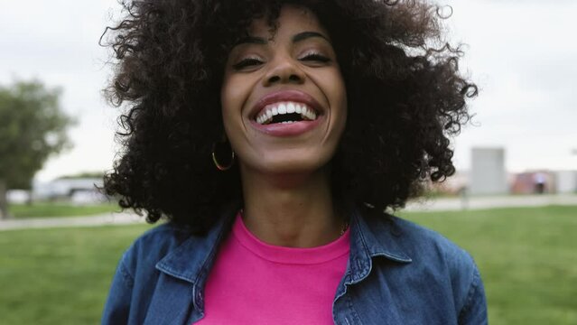 Happy Latin woman having fun dancing in a park 