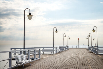 Pier with empty benches in Gdynia Orlowo, Poland. Travel destination at coastline of Baltic sea