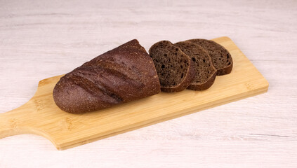 Sliced black bread on a wooden cutting board