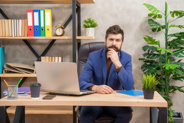 mature entrepreneur working on computer at office, online