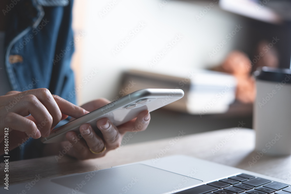 Poster closeup of business woman using and touching on mobile smart phone during working at home office wit