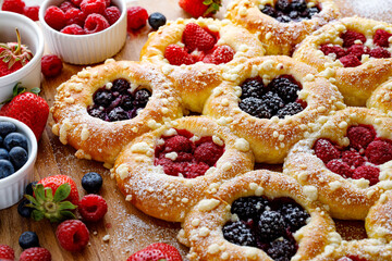 Homemade sweet yeast buns with the addition of berry fruit and butter crumble, sprinkled with...