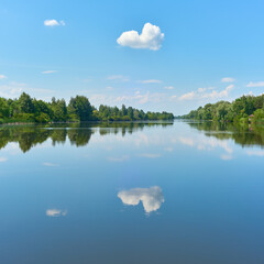Peaceful summer landscape with clouds on the blue sky over the river near Kyiv city in Ukraine.